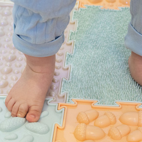 Photo d'un enfant marchant sur des dalles de motricité